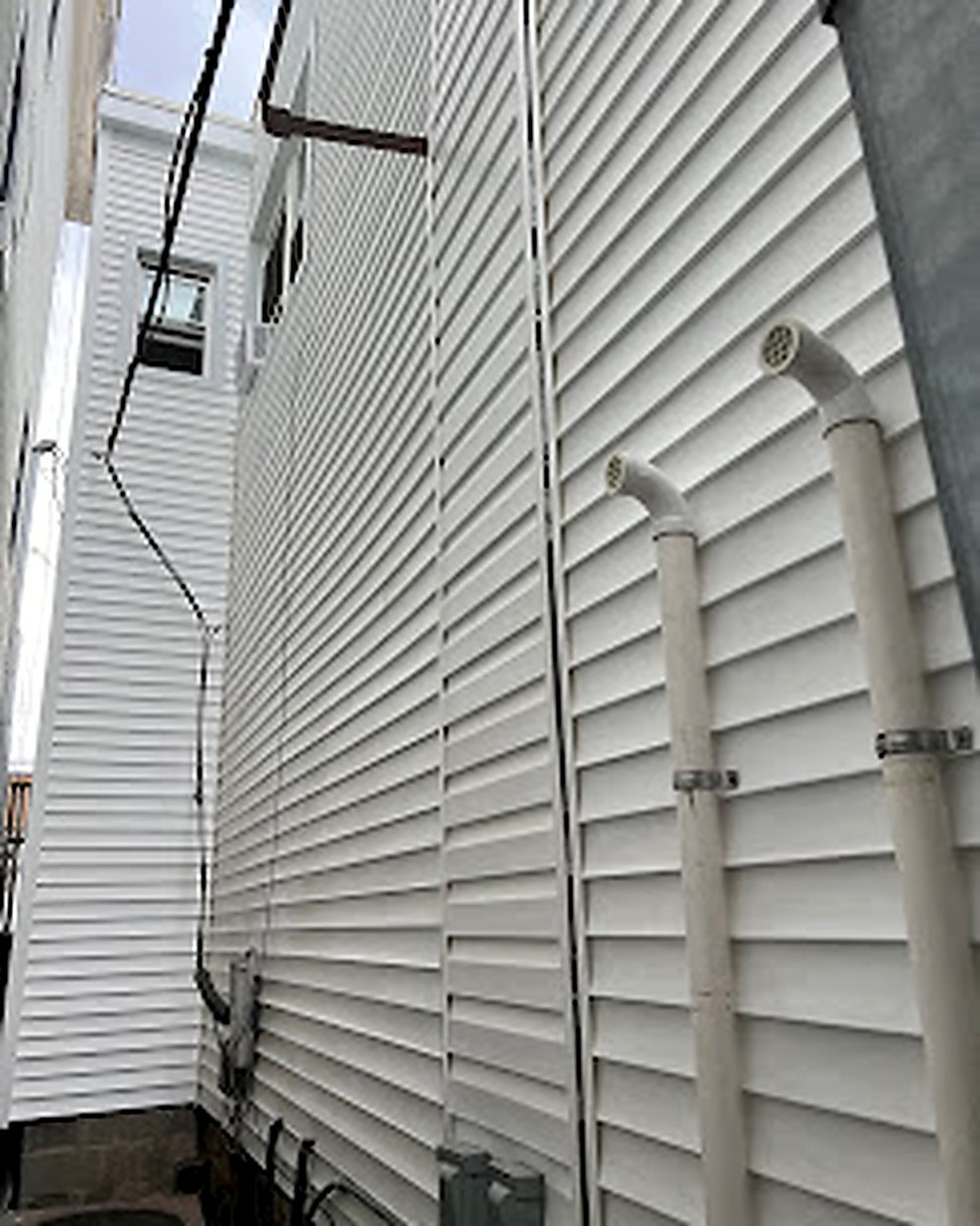 Tall white vinyl siding finished, alley view